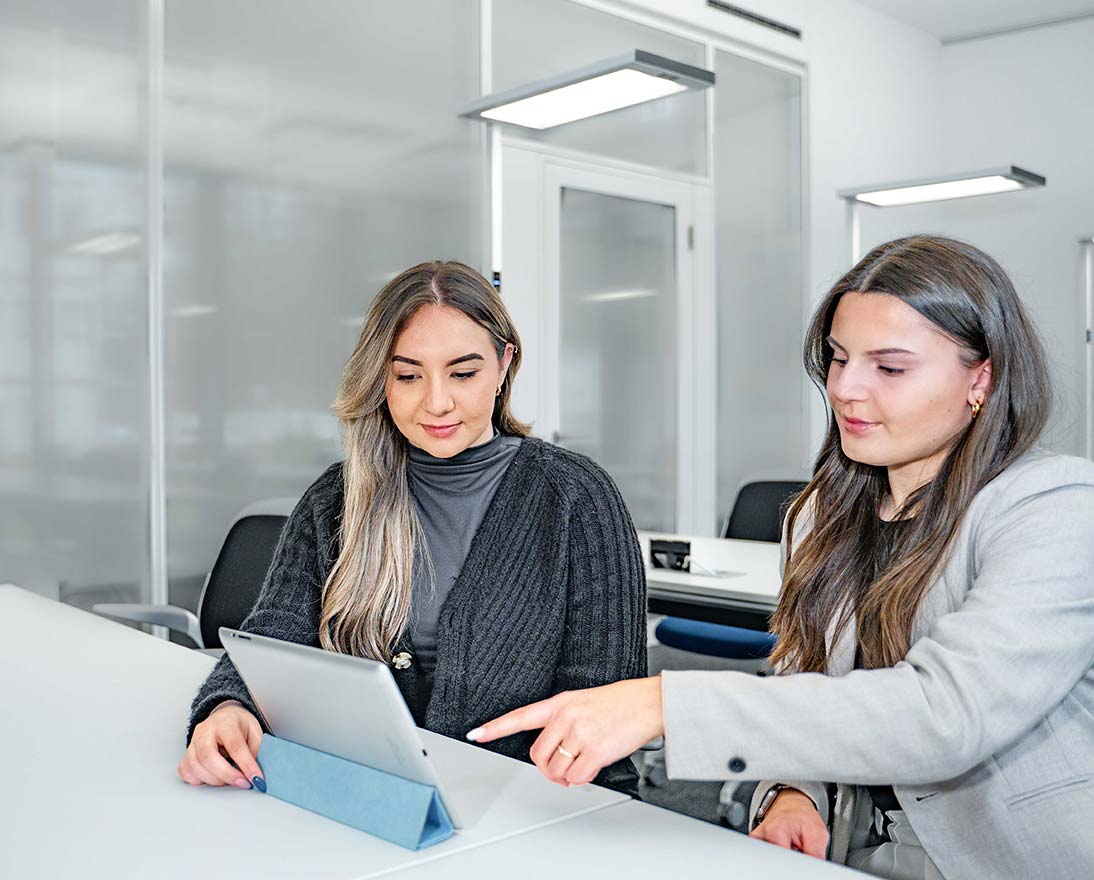 Zwei Mitarbeiterinnen schauen gemeinsam in ein Tablet.jpg
